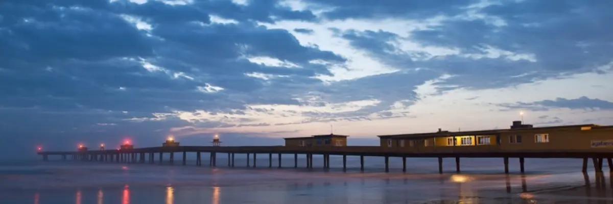 Imagem do pier da Praia de Tramandaí no fim da tarde.